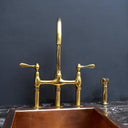 Unlacquered brass 3-hole bridge faucet – installed in farmhouse kitchen