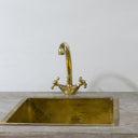Unlacquered brass gooseneck kitchen faucet – side view showing natural patina