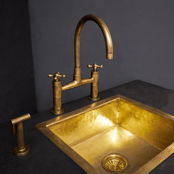 Unlacquered brass kitchen bridge faucet with sprayer and cross handles – front view