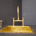 Unlacquered brass bridge faucet sprayer – close-up of cross handle